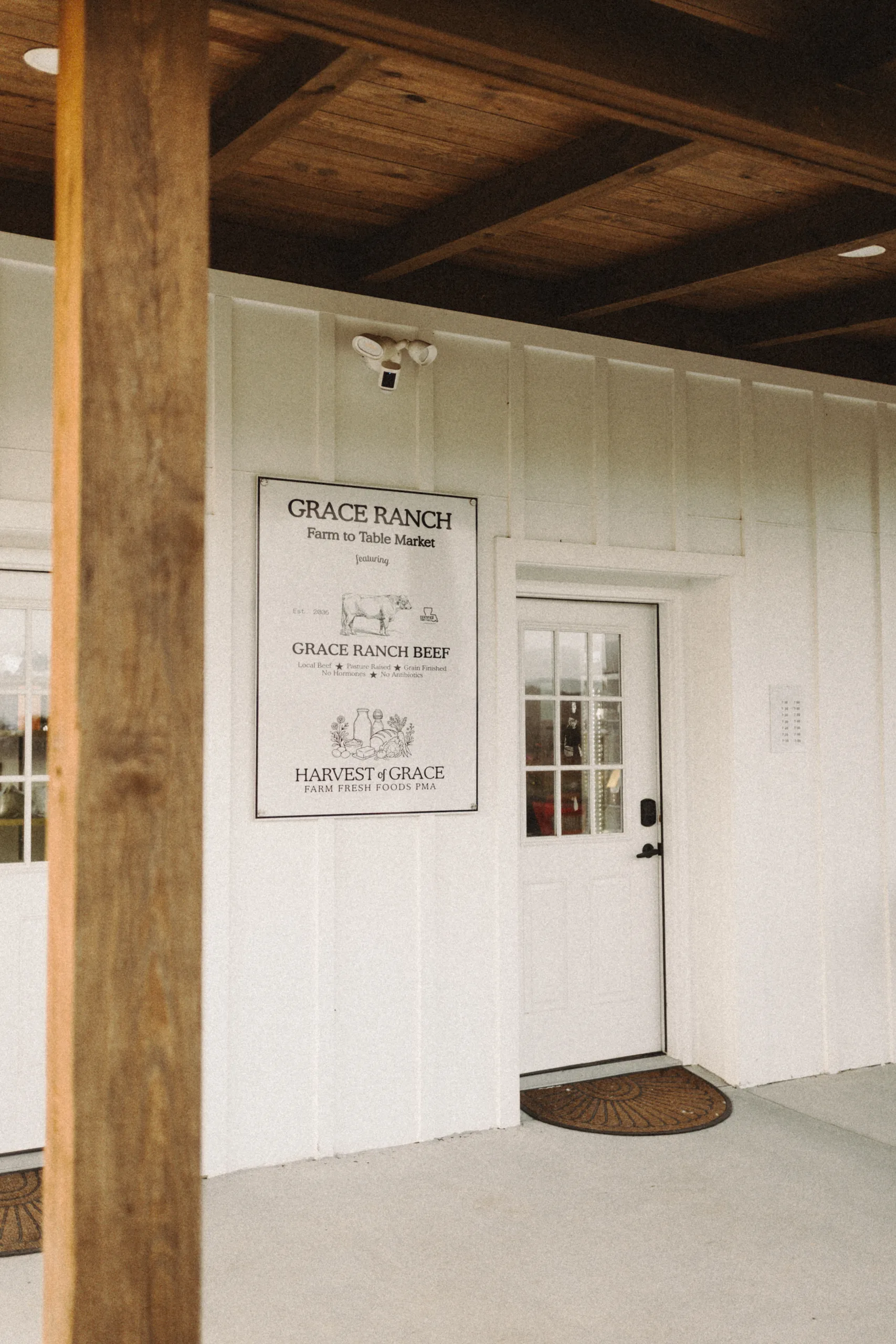 White building entrance with a Grace Ranch sign beside the door.